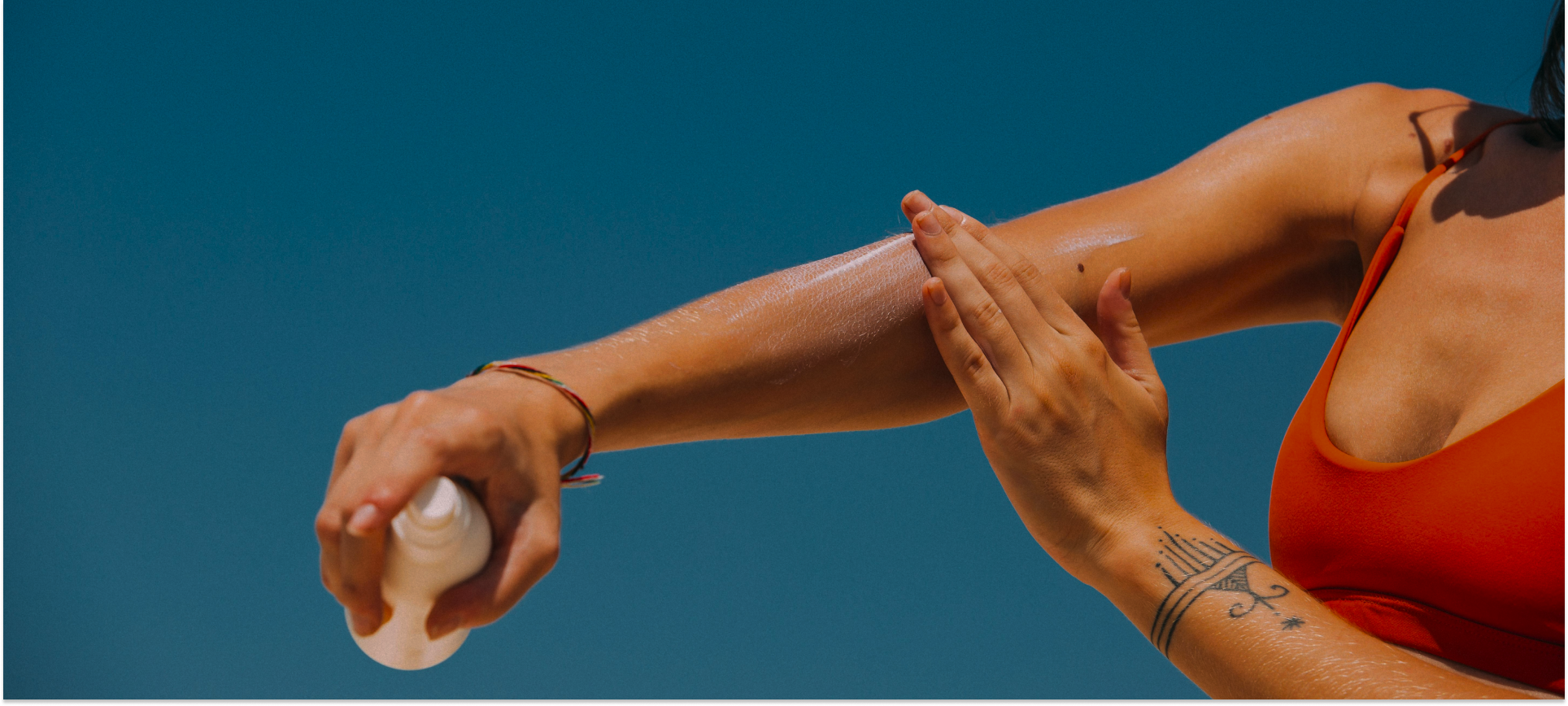 Woman applying sun cream to her arm